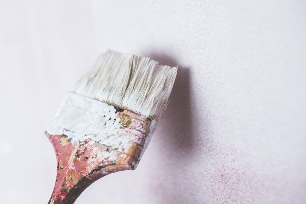 White wallpaper being painted by paintbrush
