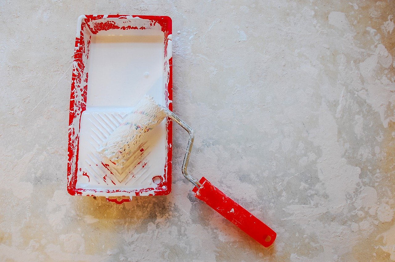 Paint tray with white paint and paint roller
